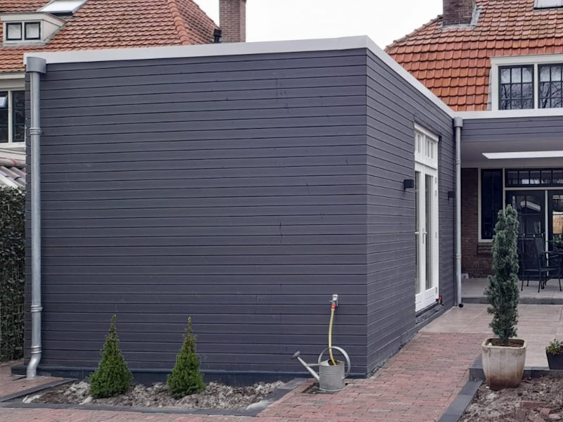 Een buitenfoto van een aanbouw
