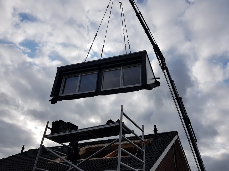 Prefab Dakkapel wordt met hijskraan op de plek getild door een hijskraan.